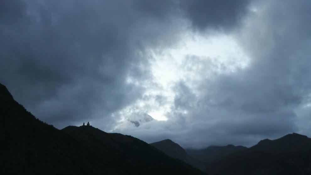 výhled z Kazbegi na vrchol, který se ještě ztrácí v mracích